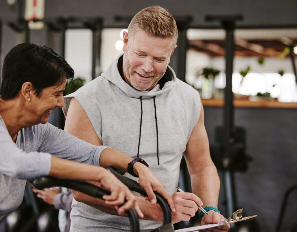 Cardio, personal trainer and senior woman, gym fitness checklist, progress or writing exercise results. Coaching, lose weight and sports professional helping elderly person on running machine workout.